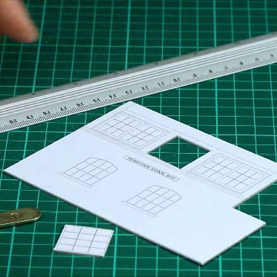 A cutting mat with a metal safety rule, a scalpel, a craft knife and a utility knife