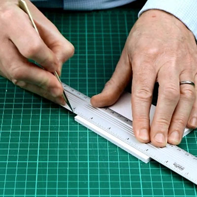 A cutting mat with a metal safety rule, scalpels and a utility knife