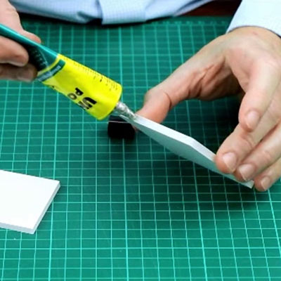 Boxes of UHU POR and UHU All Purpose glue on a cutting mat