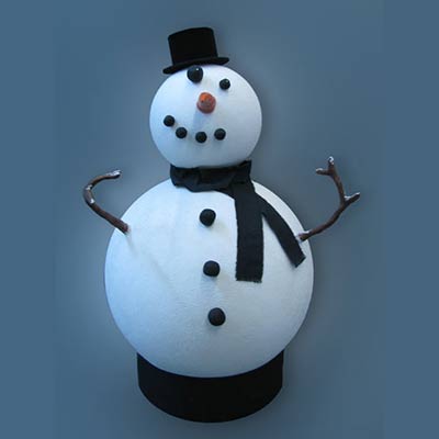 A finished white snowman with a black top hat, scarf, carrot nose, black buttons and stick arms