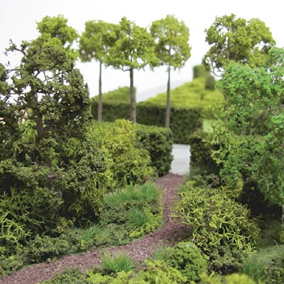 The materials for the rough scenic area laid out, including flock, textures, lichen, trees, tape and glue