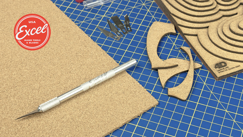 Excel craft knife and spare blades beside laser-cut card shapes on a cutting mat